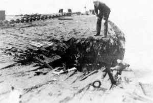 Naval officer examining bomb damage. Photo from the US National Archives.